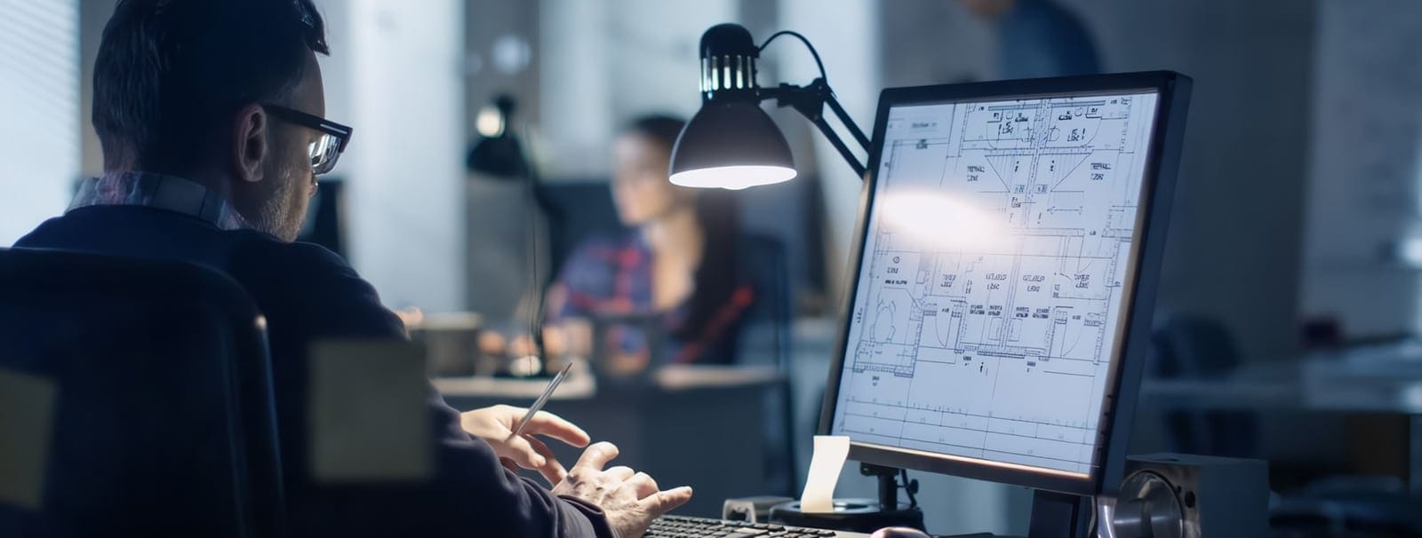 Estimator reviewing drawings on a computer monitor